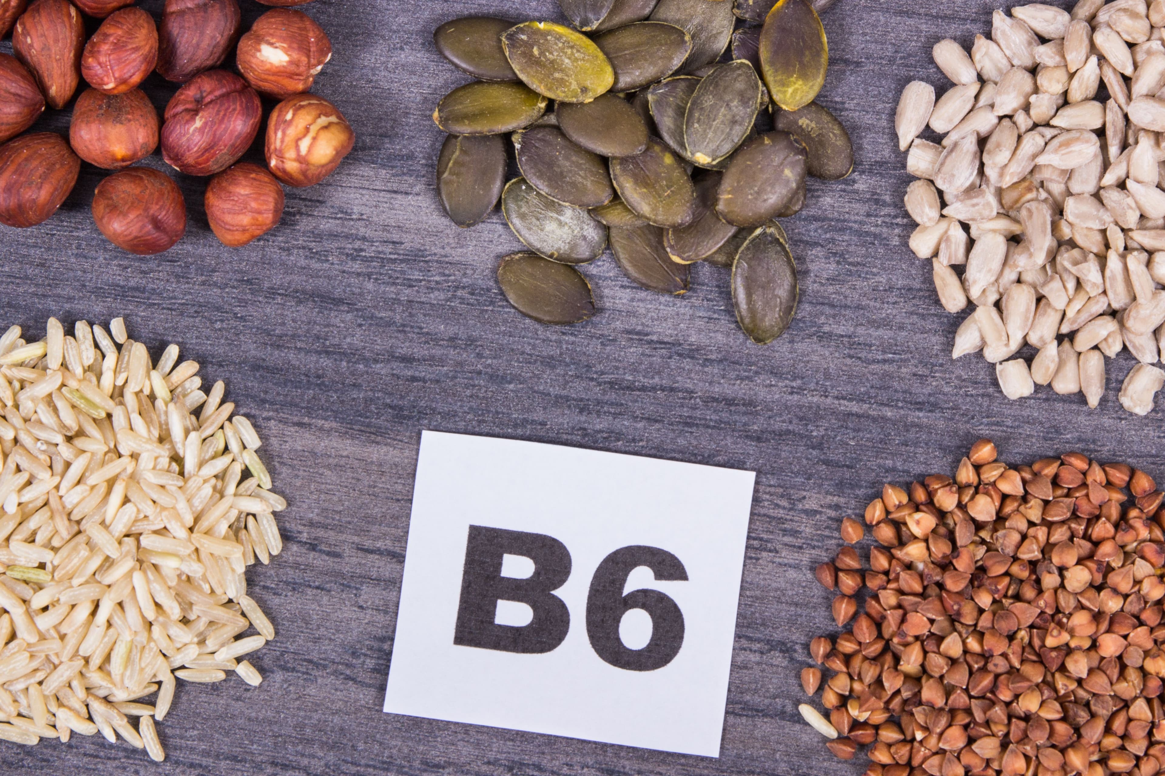 Healthy and nutritious foods rich in Vitamin B6, including seeds, grains, and nuts, displayed on a wooden surface as natural sources of essential nutrients.