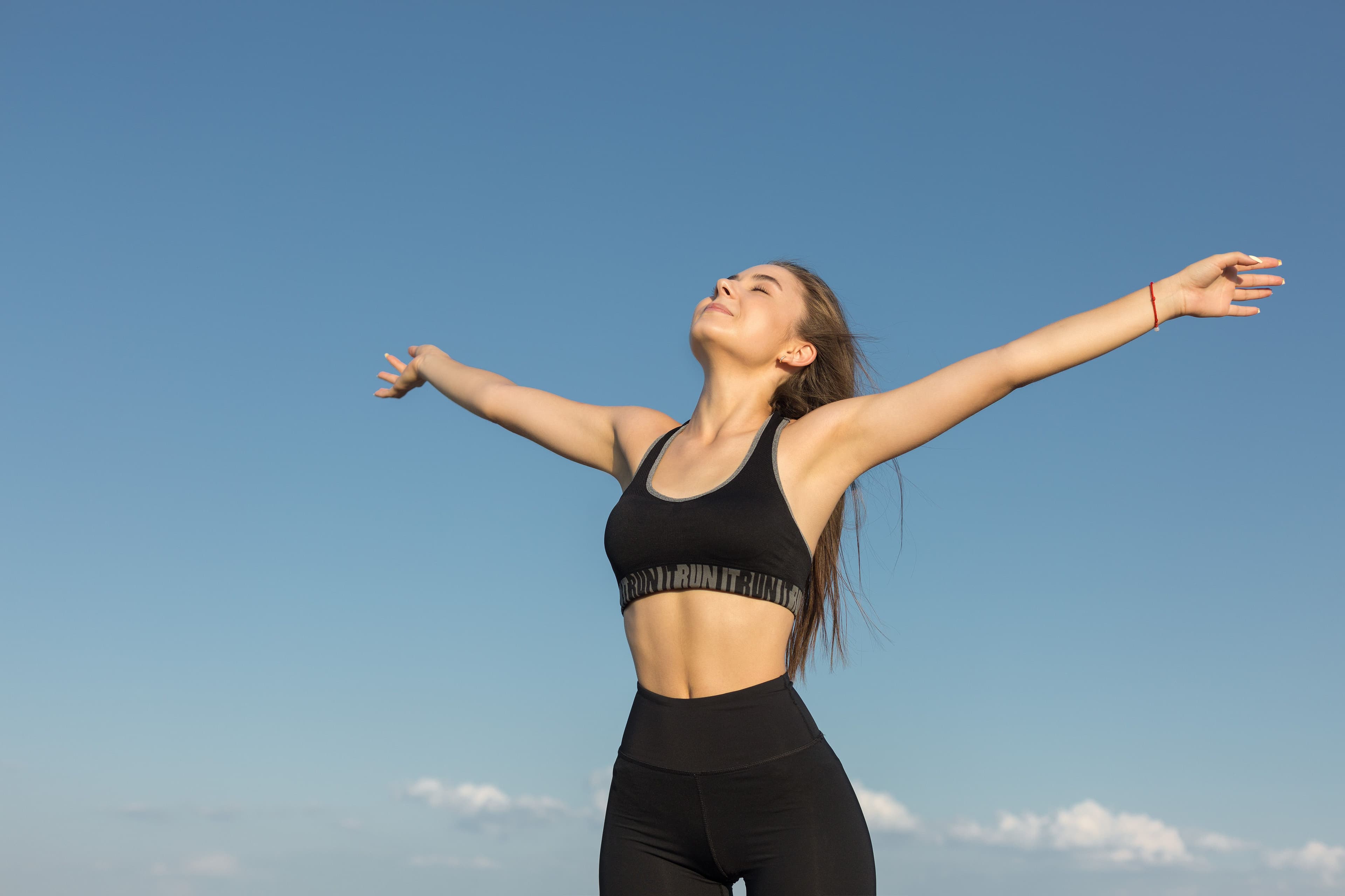 Young woman feeling energized and healthy outdoors, representing the benefits of DHEA hormone in boosting energy, vitality, and overall well-being.